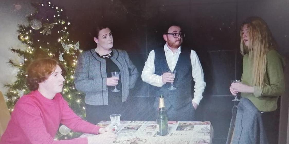 Four cast members around a table from the film A Christmas Dream
