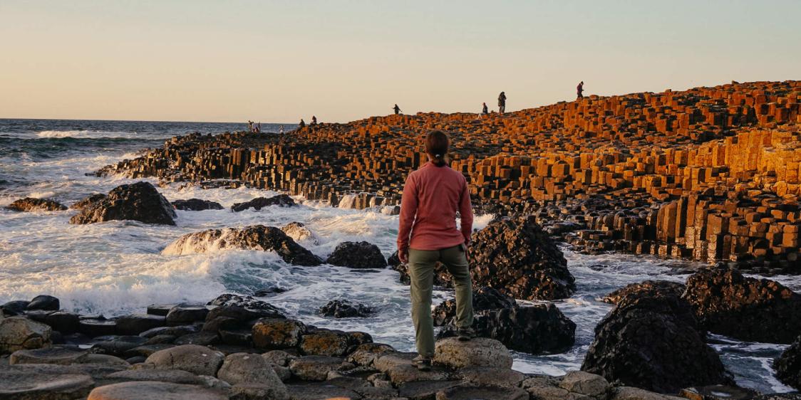 Person overlooking the Giant’s Causeway at sunset.