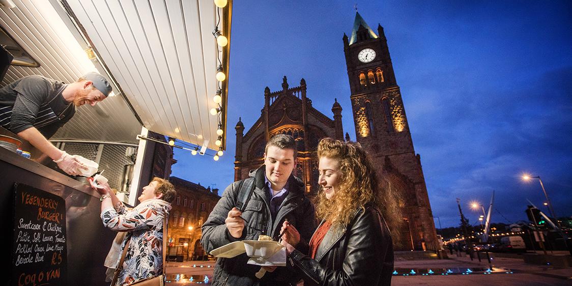 Couple eating street food from Pyke ‘N’ Pommes Derry~Londonderry. 