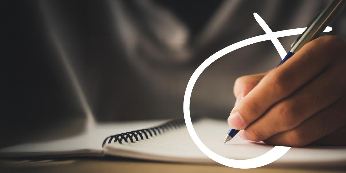 Close-up of a hand writing with a pen on a spiral-bound notebook, with a white curved graphic element overlaid on the image.