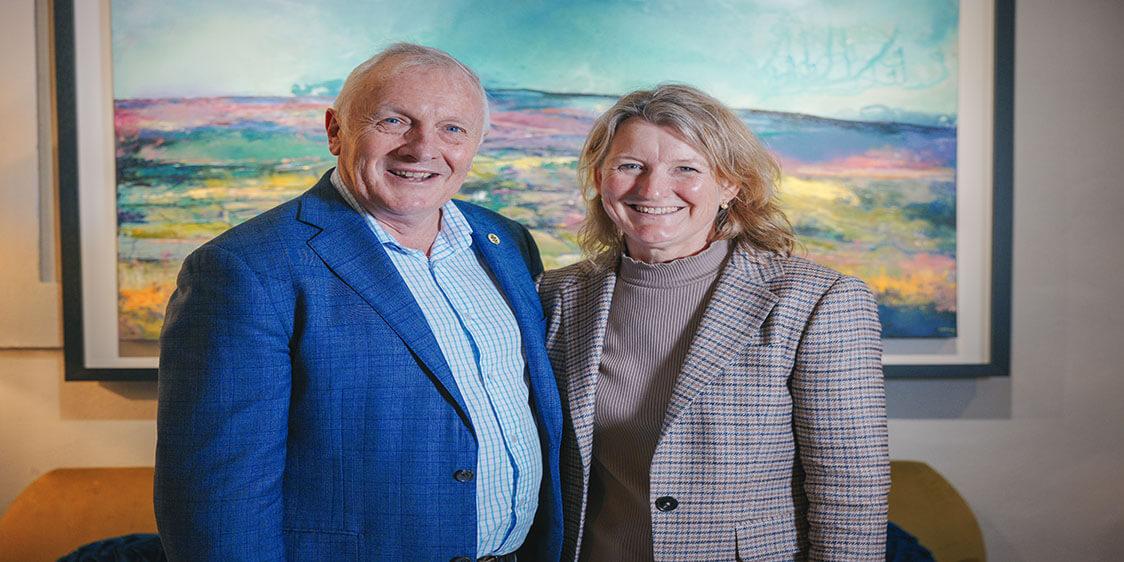 Picture of Mick & Robin Boyle standing in front of artwork on a wall