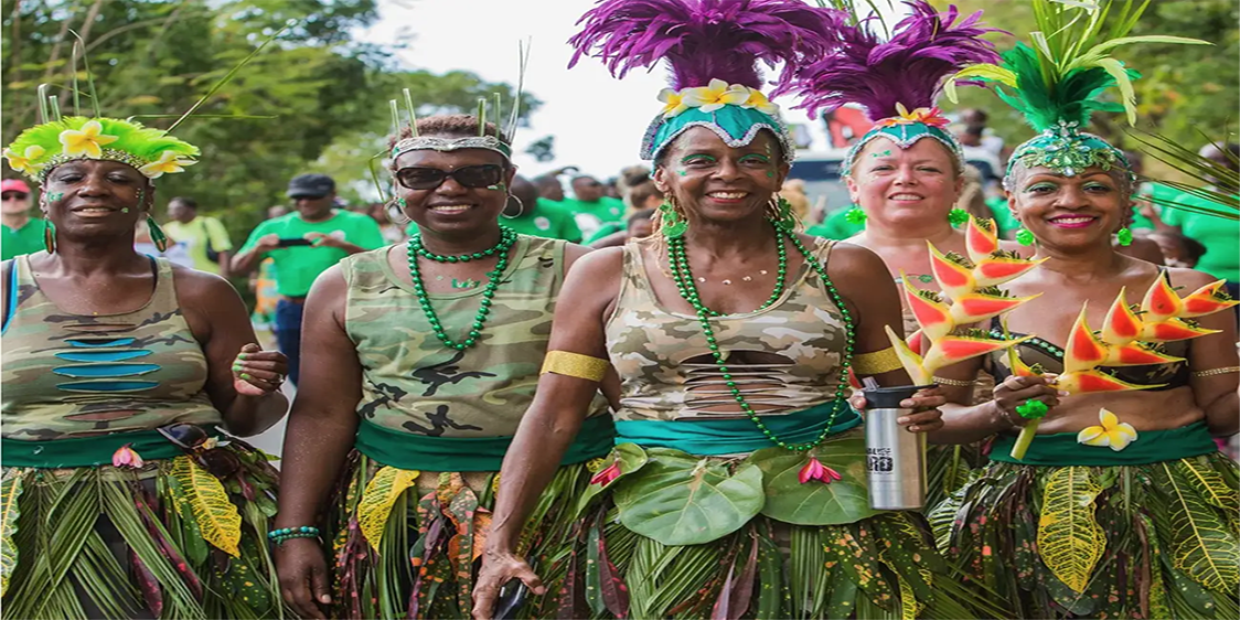 People taking part in St Patrick’s Day festivities in Montserrat, wearing green outfits and decorative headpieces during a street celebration.