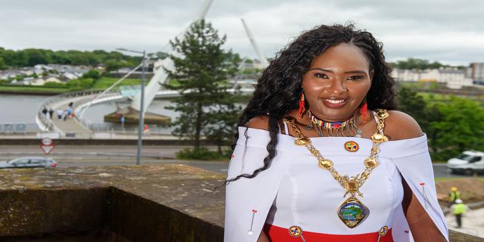 Image of the Mayor of Derry, Lilian Seenoi-Barr in front of the Peace Bridge