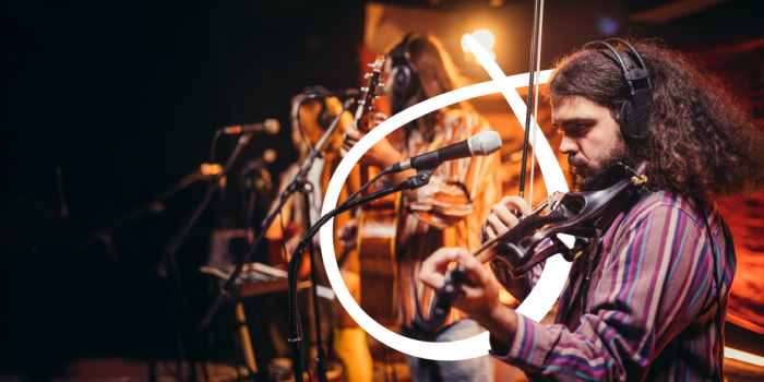 Man playing fiddle in a band on stage